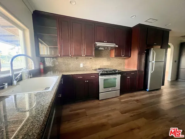 a kitchen with granite countertop stainless steel appliances and wooden cabinets