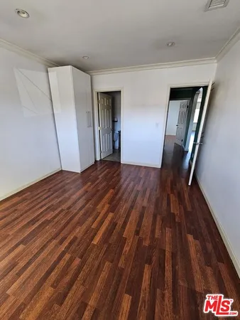 a view of an empty room with wooden floor and entryway