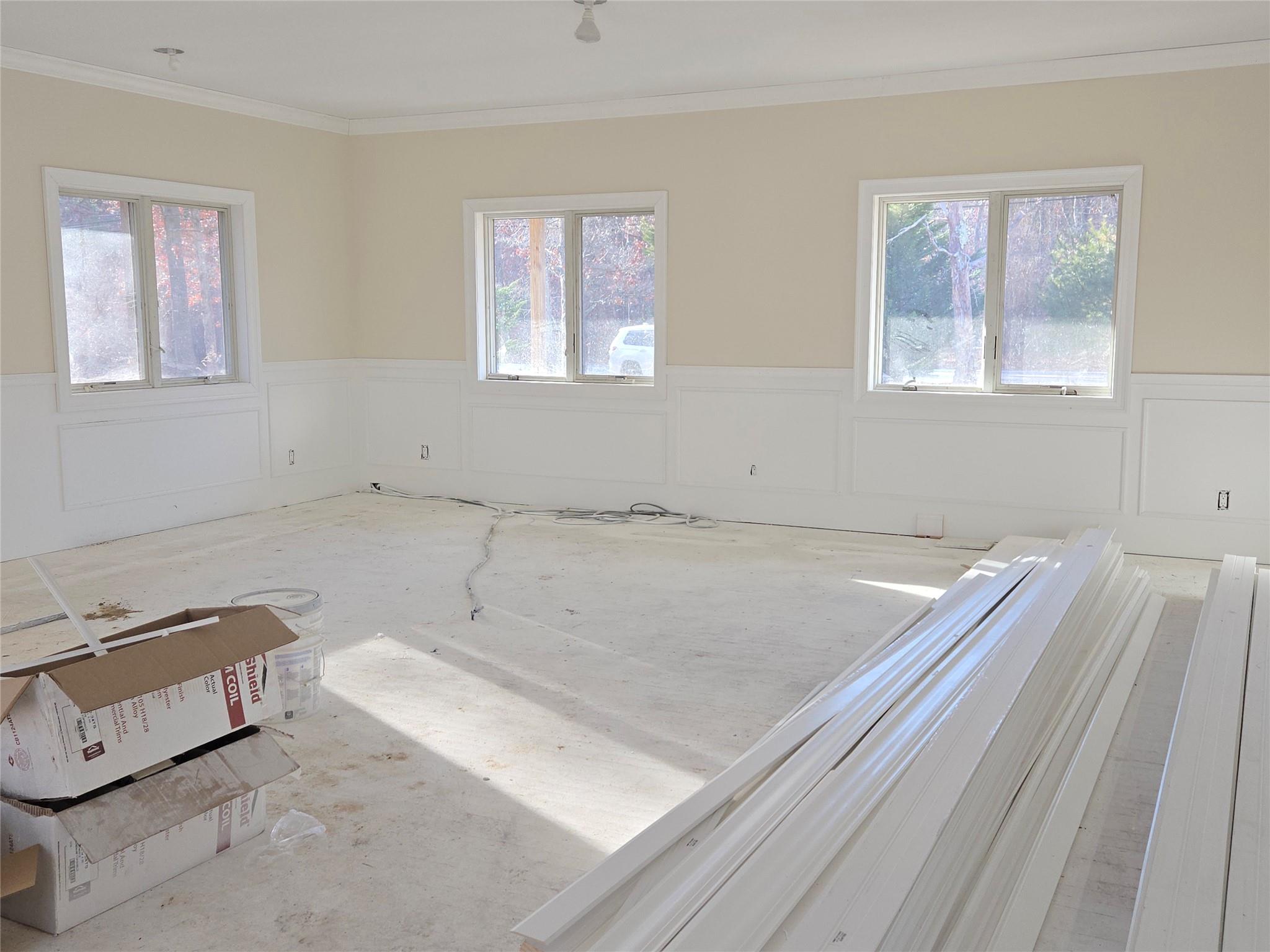 85 Smith Road Ridge, NY 11961 - Photo 11 of 26 Unfurnished room featuring a wainscoted wall, crown molding, healthy amount of natural light, and a decorative wall