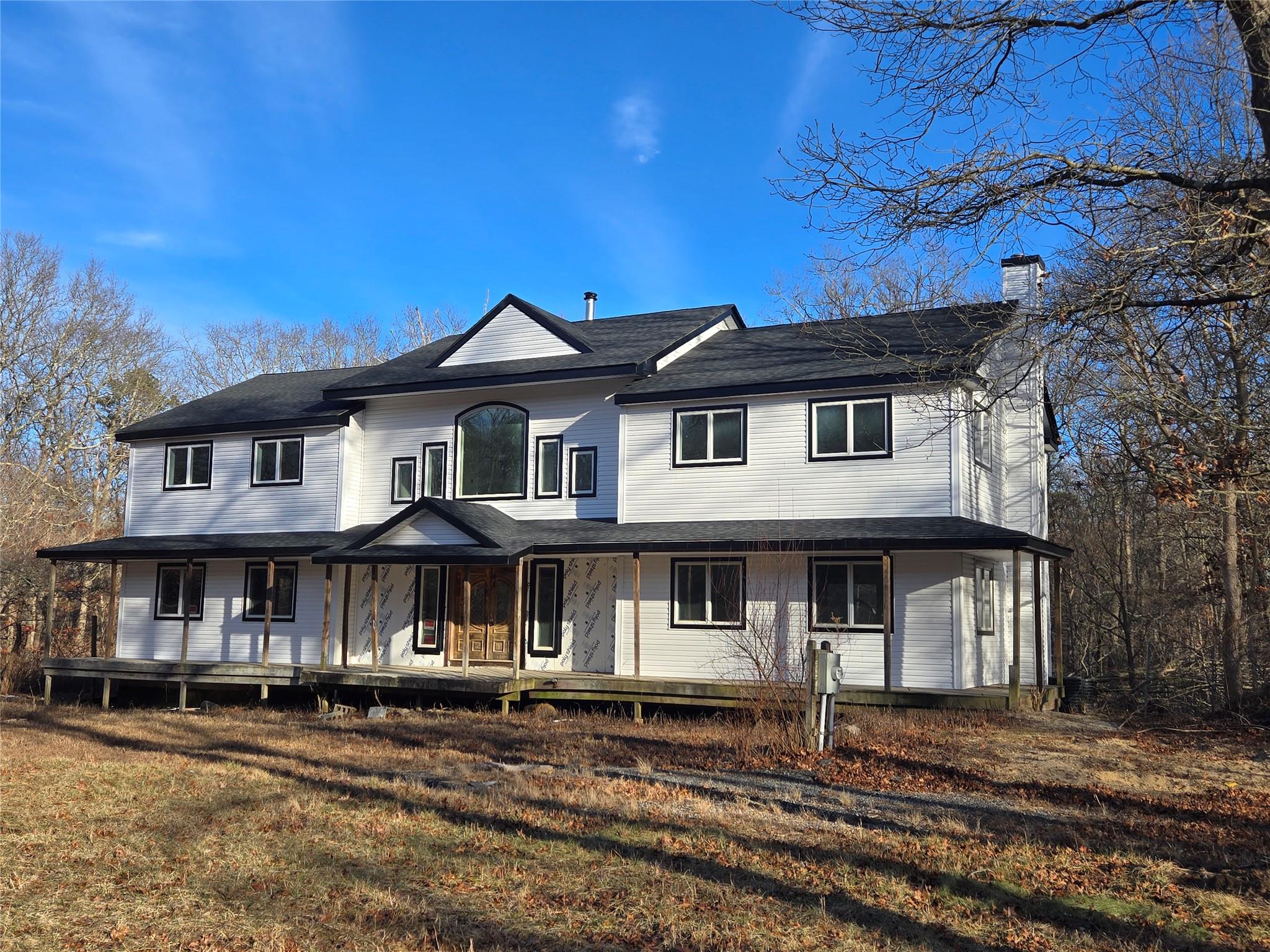 85 Smith Road Ridge, NY 11961 - Photo 2 of 26 Rear view of house featuring a chimney and a porch