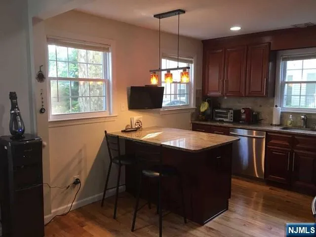 a kitchen with a sink a window a dining table and cabinetry