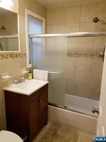a bathroom with a sink and mirror with toilet