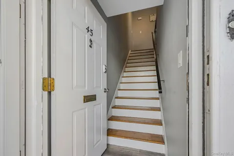 a view of a hallway with a door and stairs