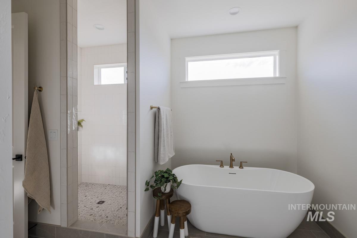 6091 South Apex Avenue Meridian, ID 83642 - Photo 29 of 40 Bathroom with a walk in shower, a soaking tub, plenty of natural light, and tile patterned floors