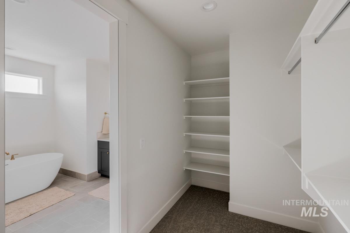 6091 South Apex Avenue Meridian, ID 83642 - Photo 32 of 40 Walk in closet featuring dark tile patterned floors