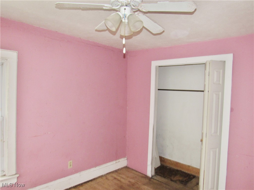 14450 Superior Road Cleveland, OH 44118 - Photo 19 of 35 Unfurnished bedroom featuring wood finished floors, a closet, baseboards, and ceiling fan