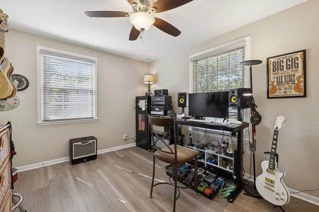 a living room with furniture a flat screen tv and floor to ceiling window