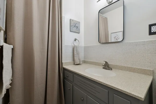 a view of a refrigerator in kitchen and an empty room