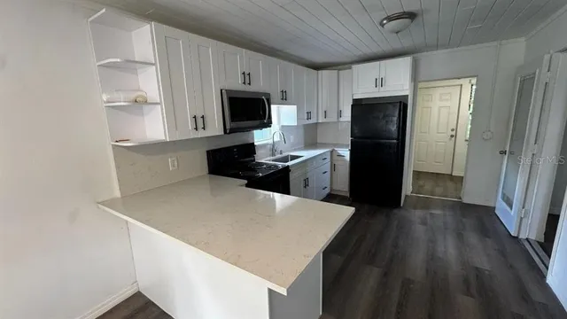 a kitchen with stainless steel appliances a refrigerator stove microwave and sink