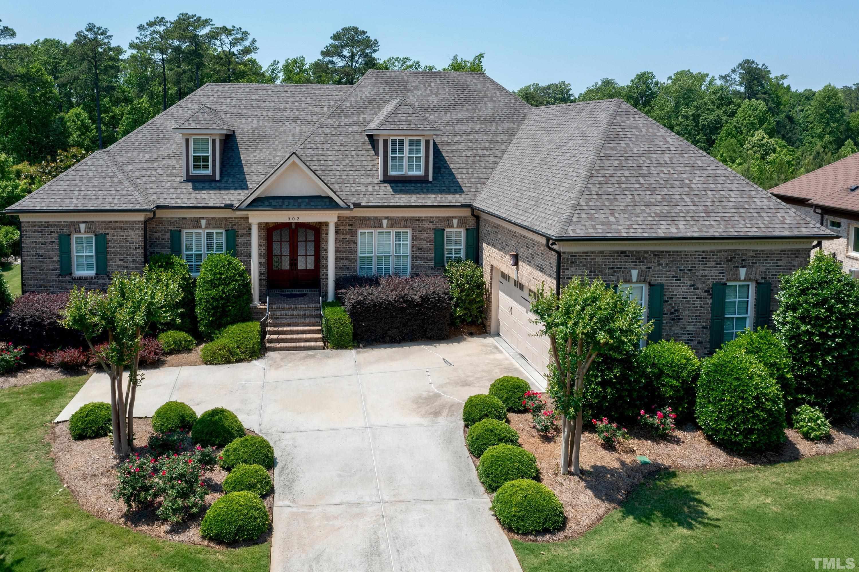 a front view of a house with a yard and potted plants