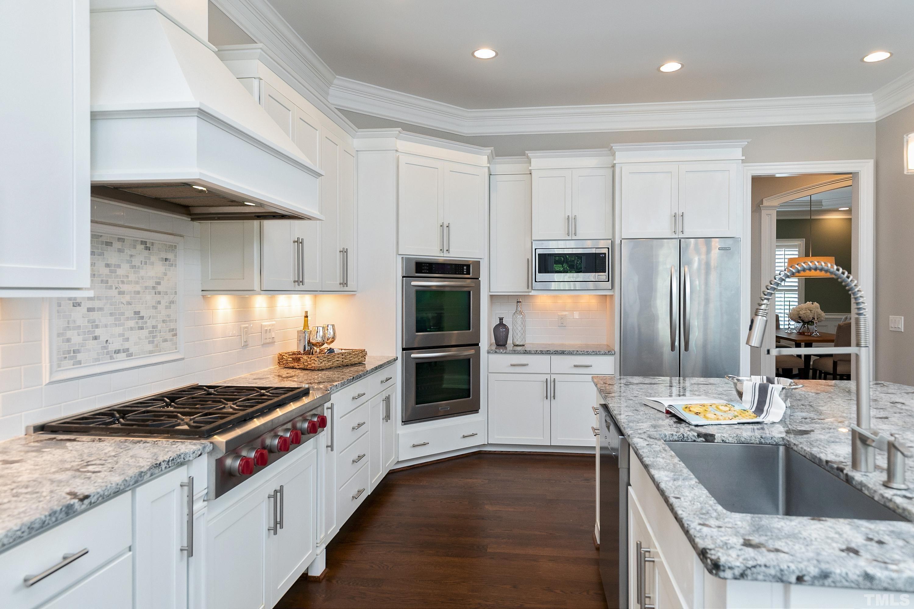 302 Michelangelo Way Cary, NC 27518 - Photo 6 of 44 a kitchen with stainless steel appliances granite countertop a stove and a sink