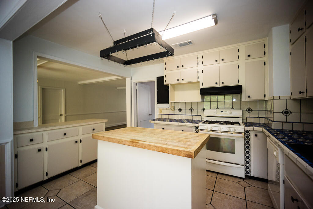 9965 Arnold Road Jacksonville, FL 32246 - Photo 24 of 60 a kitchen with granite countertop a sink a stove and cabinets
