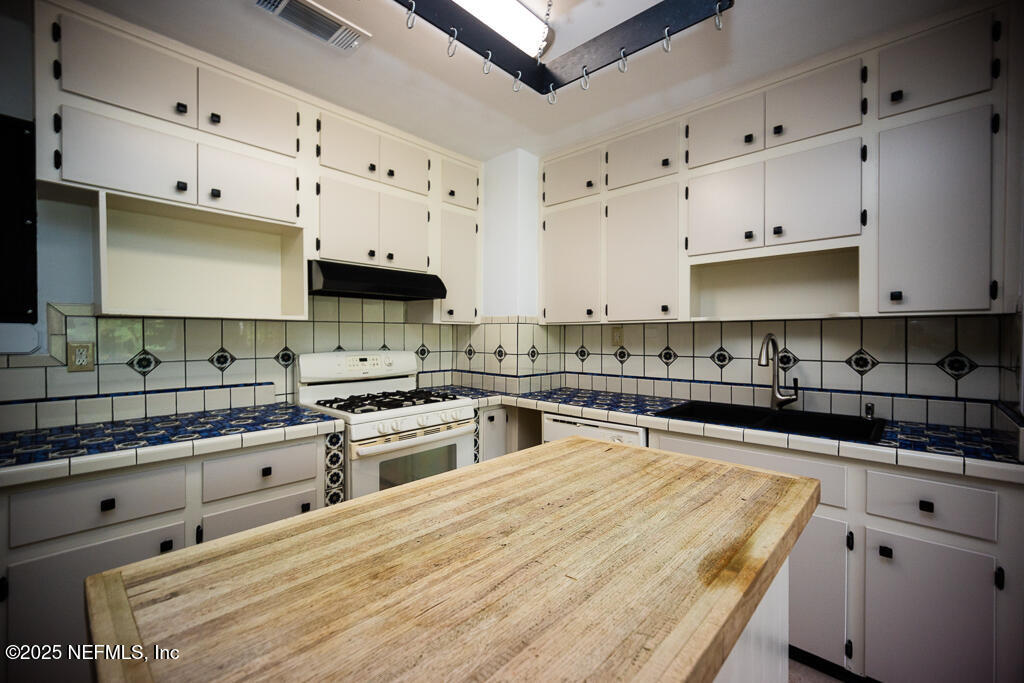 9965 Arnold Road Jacksonville, FL 32246 - Photo 25 of 60 a large kitchen with stainless steel appliances granite countertop a stove and a white cabinets
