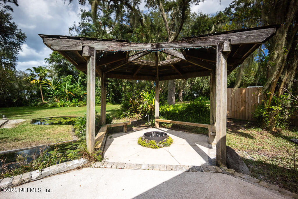 9965 Arnold Road Jacksonville, FL 32246 - Photo 42 of 60 a view of a patio with table and chairs under an umbrella