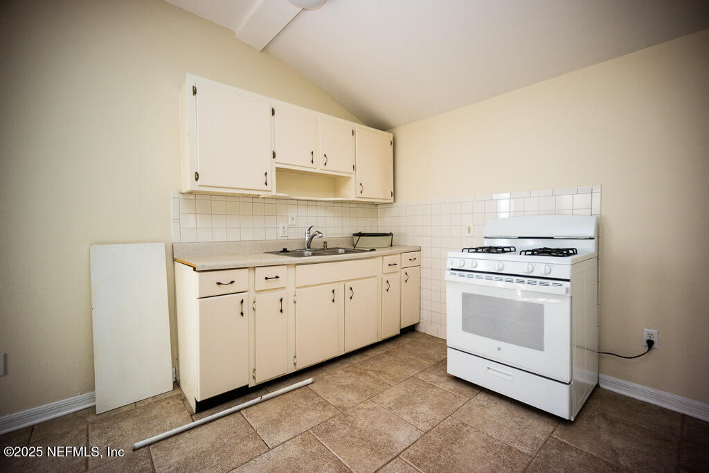 9965 Arnold Road Jacksonville, FL 32246 - Photo 52 of 60 a kitchen with granite countertop white cabinets and white appliances