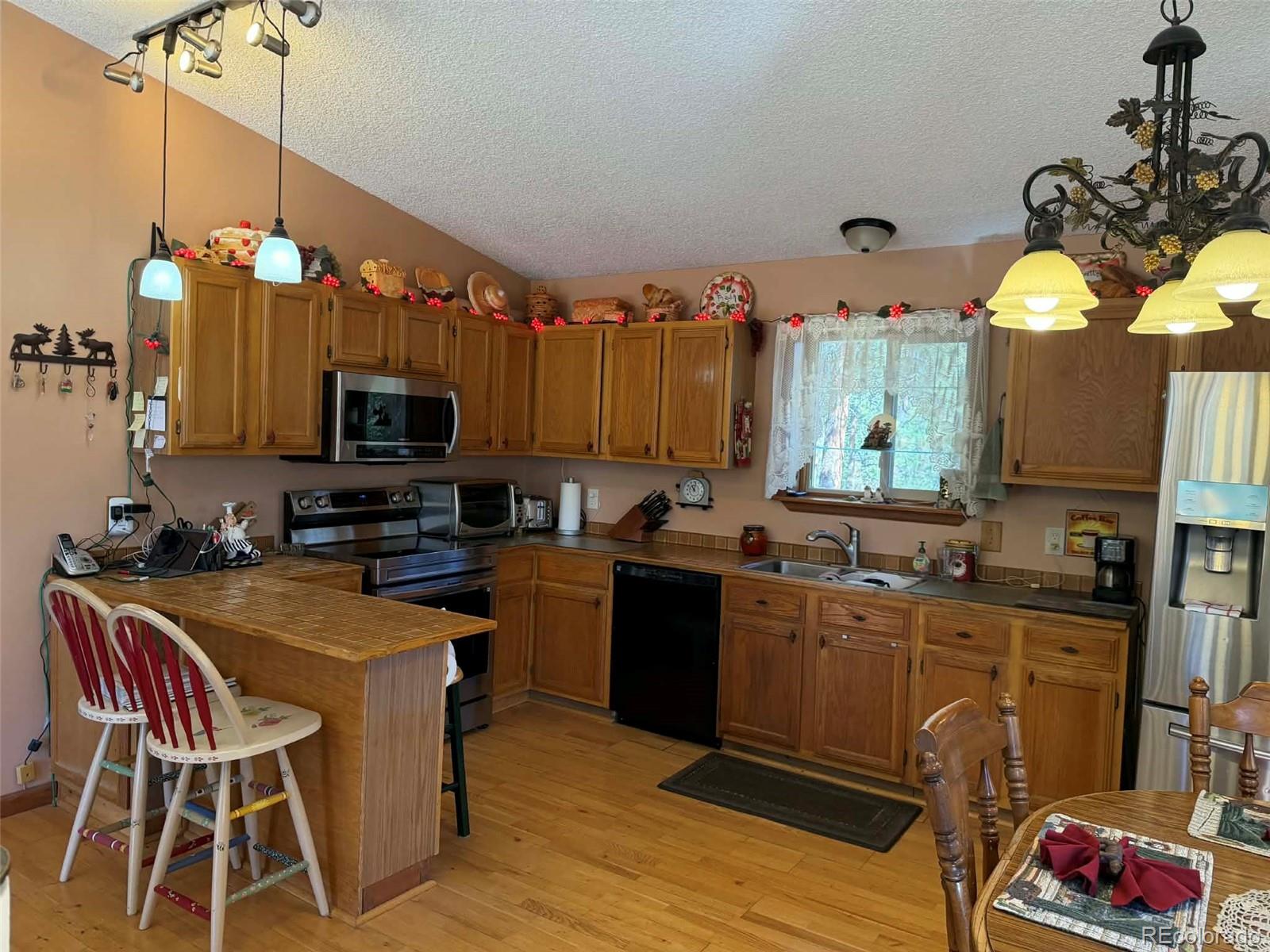 33623 Smith Road Pine, CO 80470 - Photo 3 of 45 a kitchen with a sink a stove and chairs