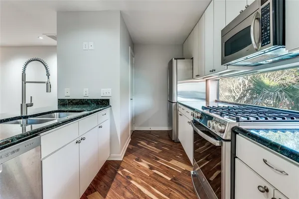 a kitchen with granite countertop a stove and a sink