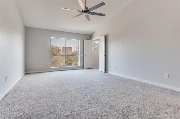 an empty room with windows and fan
