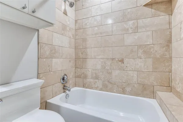 a white bath tub sitting next to a white toilet