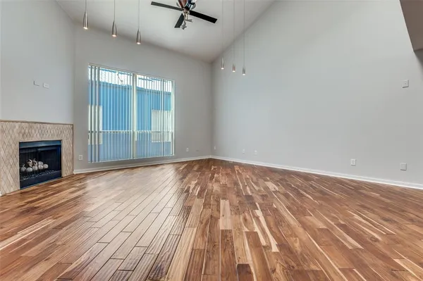 a view of empty room with wooden floor and fireplace