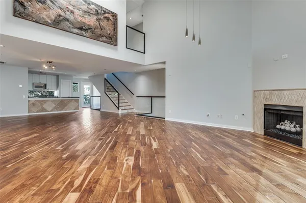 a view of empty room with wooden floor and fireplace