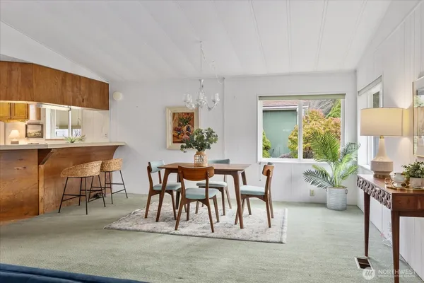 a living room with furniture a rug potted plant and a window