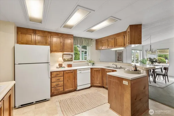 a kitchen with a refrigerator a stove a sink and a dining table