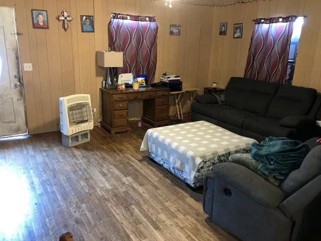 a living room with furniture a flat screen tv and kitchen view