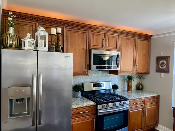 a kitchen with stainless steel appliances granite countertop a stove a sink and a refrigerator