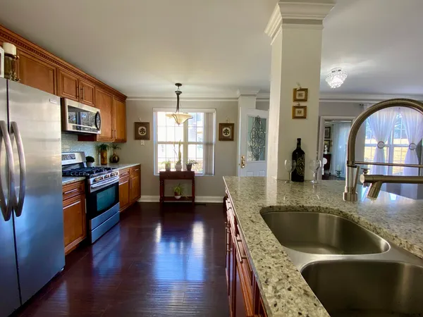 a kitchen with stainless steel appliances granite countertop a sink a stove and a refrigerator