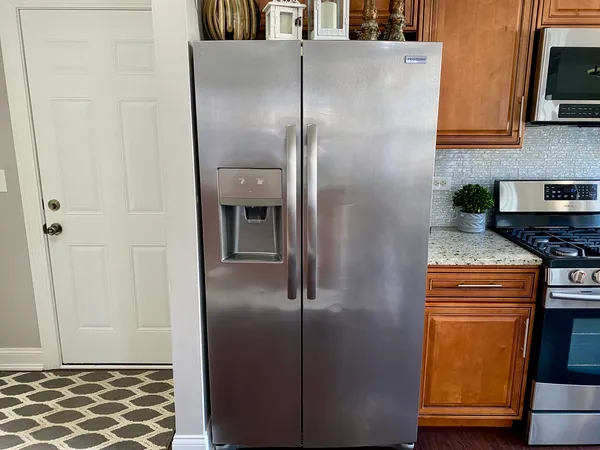 a kitchen with metallic refrigerator and cabinets