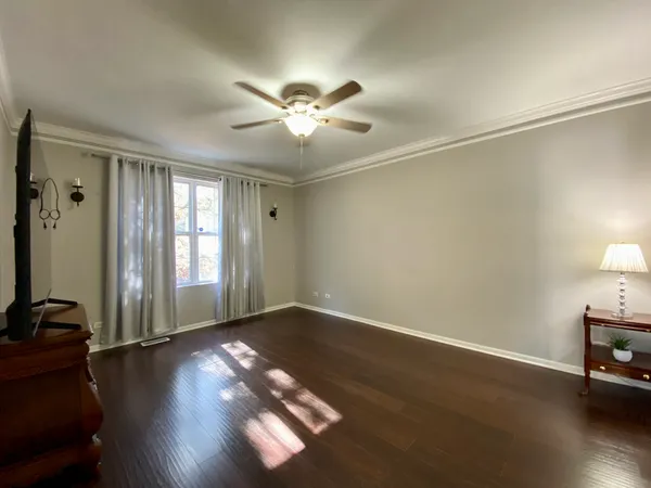 a view of an empty room with window and wooden floor