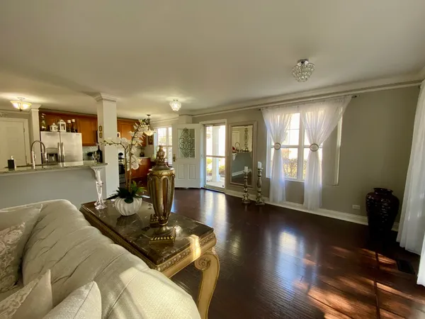 a living room with furniture a wooden floor and next to a window