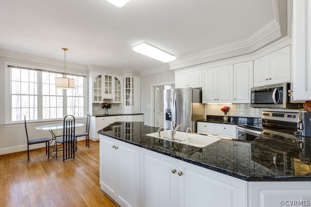 11902 Reeds Bluff Lane Midlothian, VA 23113 - Photo 13 of 42 a kitchen with stainless steel appliances granite countertop a refrigerator a stove a sink a dining table and chairs with wooden floor