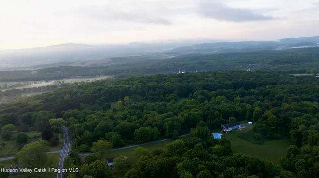 an aerial view of residential houses with outdoor space and trees