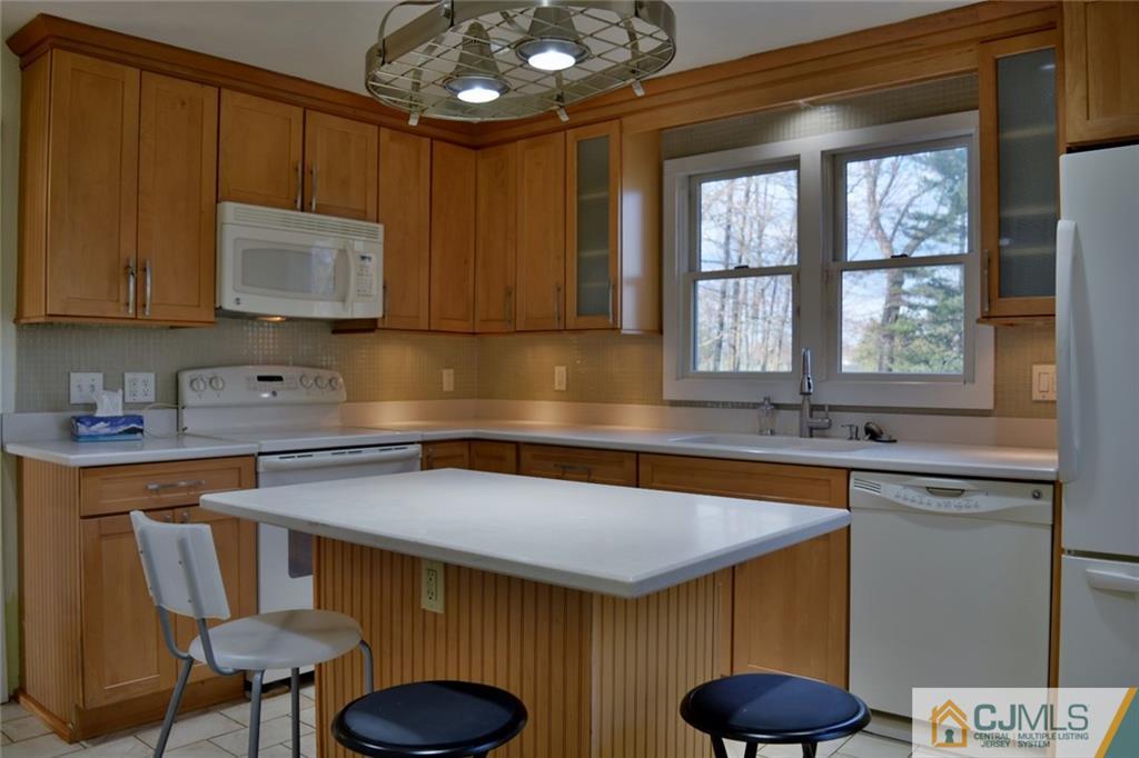 292 Georges Road Dayton, NJ 08810 - Photo 4 of 19 a kitchen with stainless steel appliances granite countertop a sink a stove and a wooden cabinets