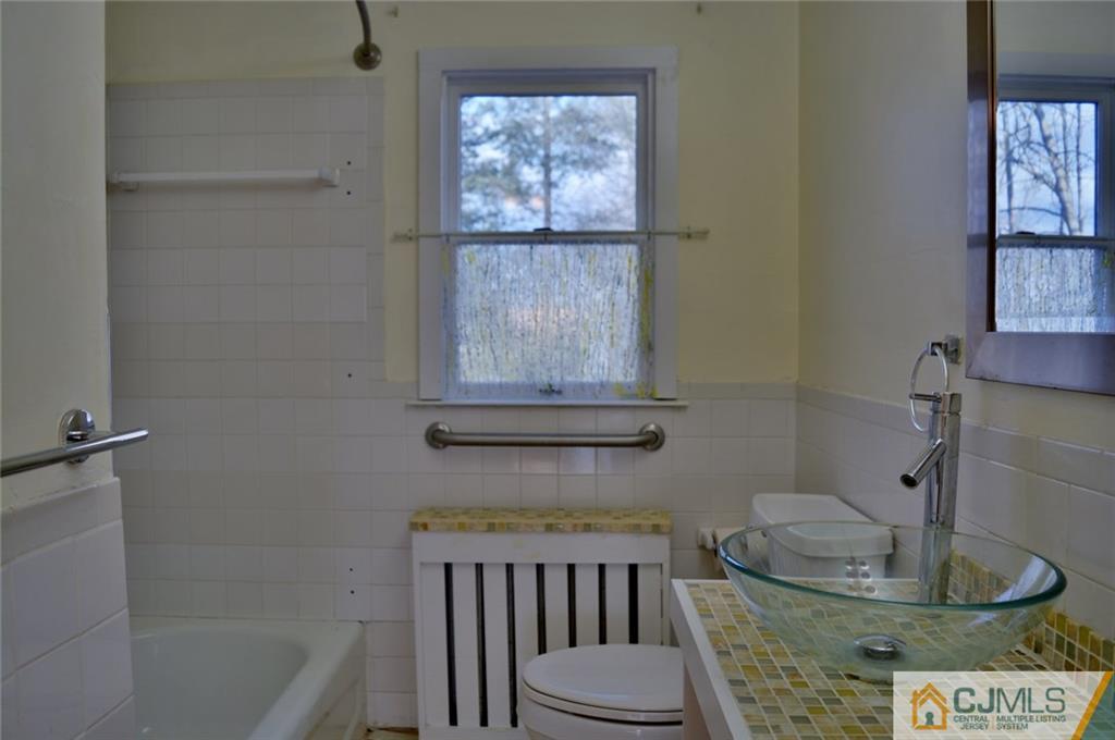 292 Georges Road Dayton, NJ 08810 - Photo 8 of 19 a bathroom with a toilet a sink and a window