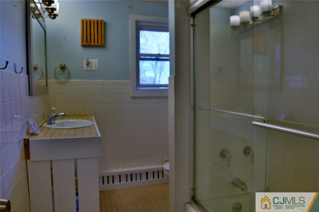 292 Georges Road Dayton, NJ 08810 - Photo 10 of 19 a bathroom with a sink a mirror and shower