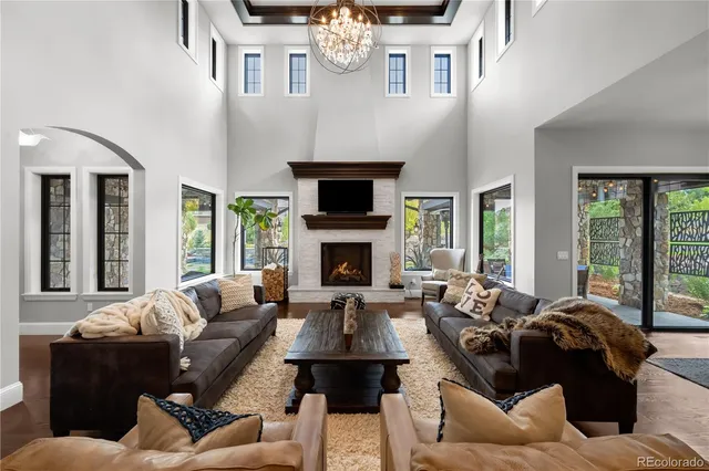 a living room with furniture large window and fireplace