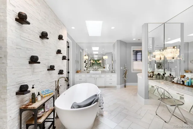 a large white bathroom with a large tub shower sink and mirror