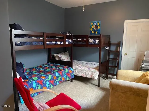 a bedroom with a bed and a lamp on dresser