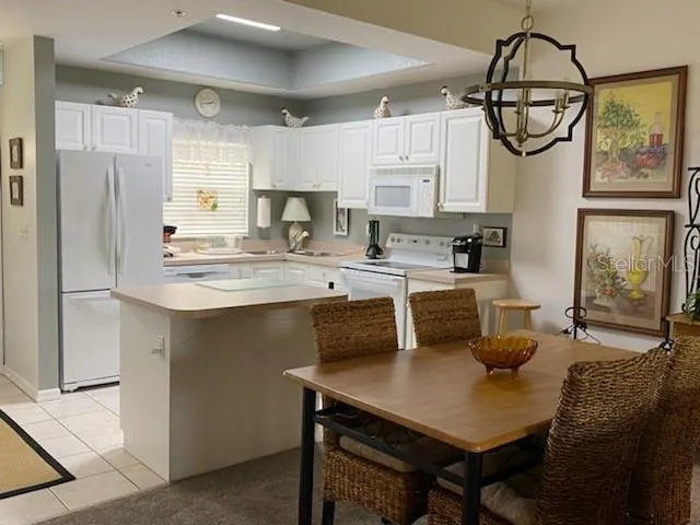 a kitchen with stainless steel appliances a table chairs and a refrigerator