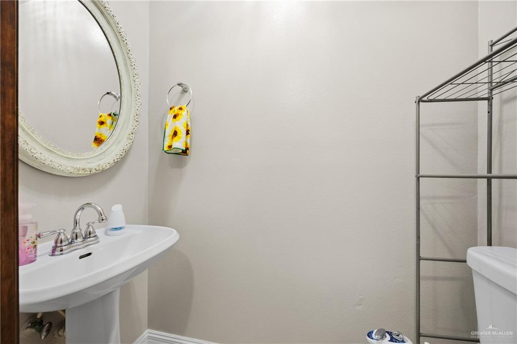 1811 Victoria Street Mission, TX 78572 - Photo 15 of 19 a bathroom with a sink mirror and toilet
