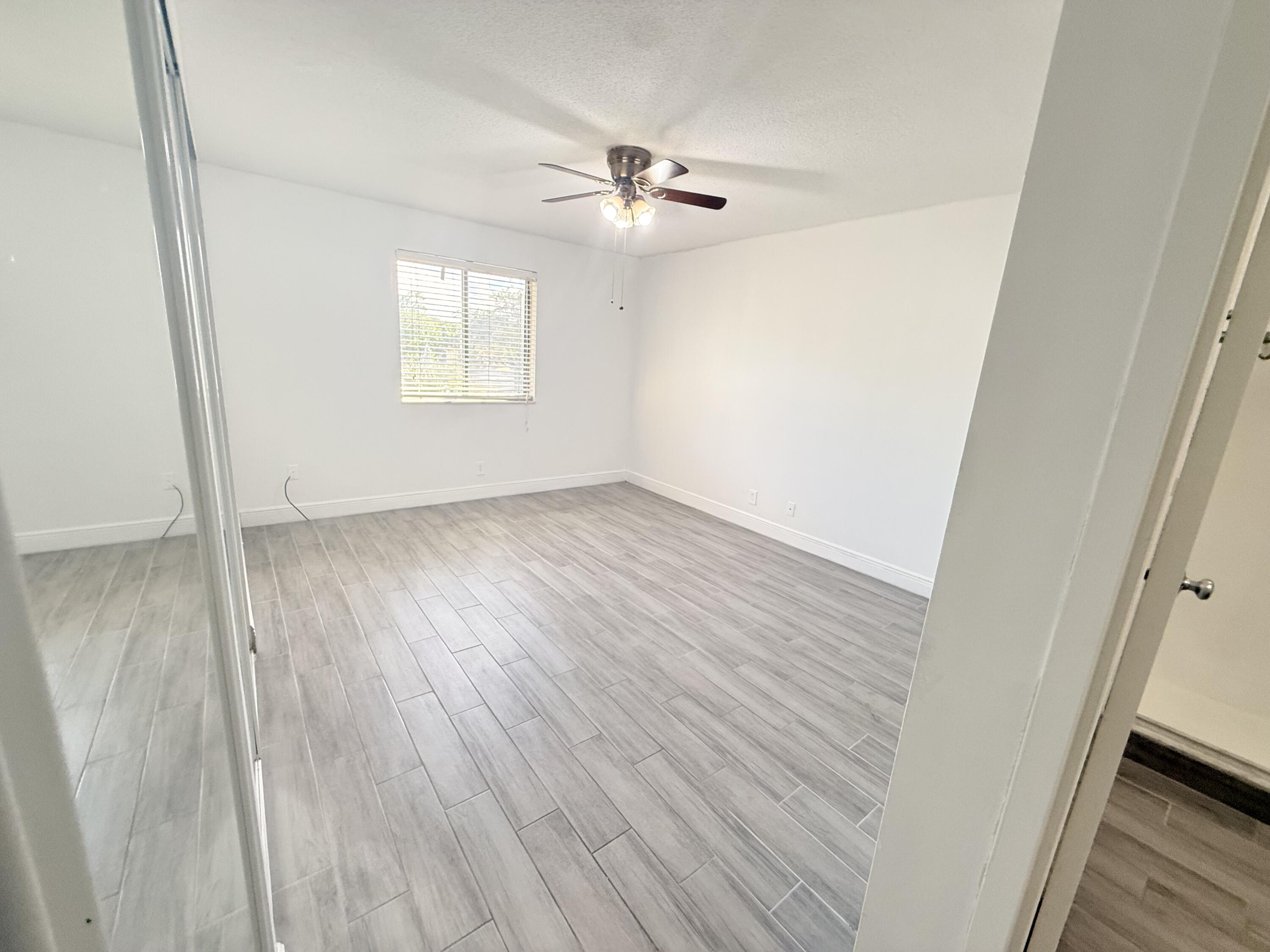 906 Southwest 9th St Circle, Unit 204 Boca Raton, FL 33486 - Photo 15 of 39 a view of an empty room with wooden floor and a window