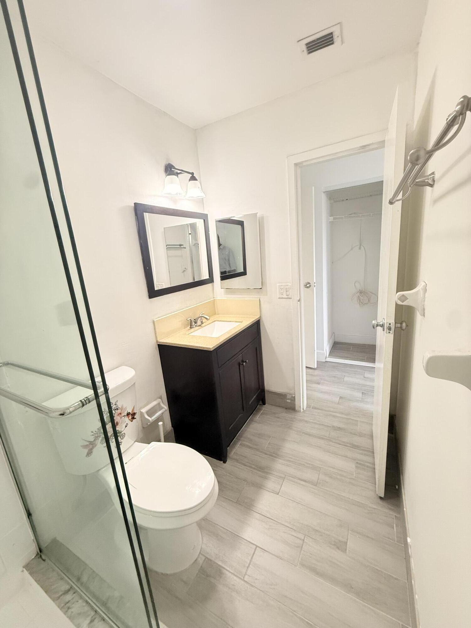 906 Southwest 9th St Circle, Unit 204 Boca Raton, FL 33486 - Photo 18 of 39 a bathroom with a toilet a sink and a mirror