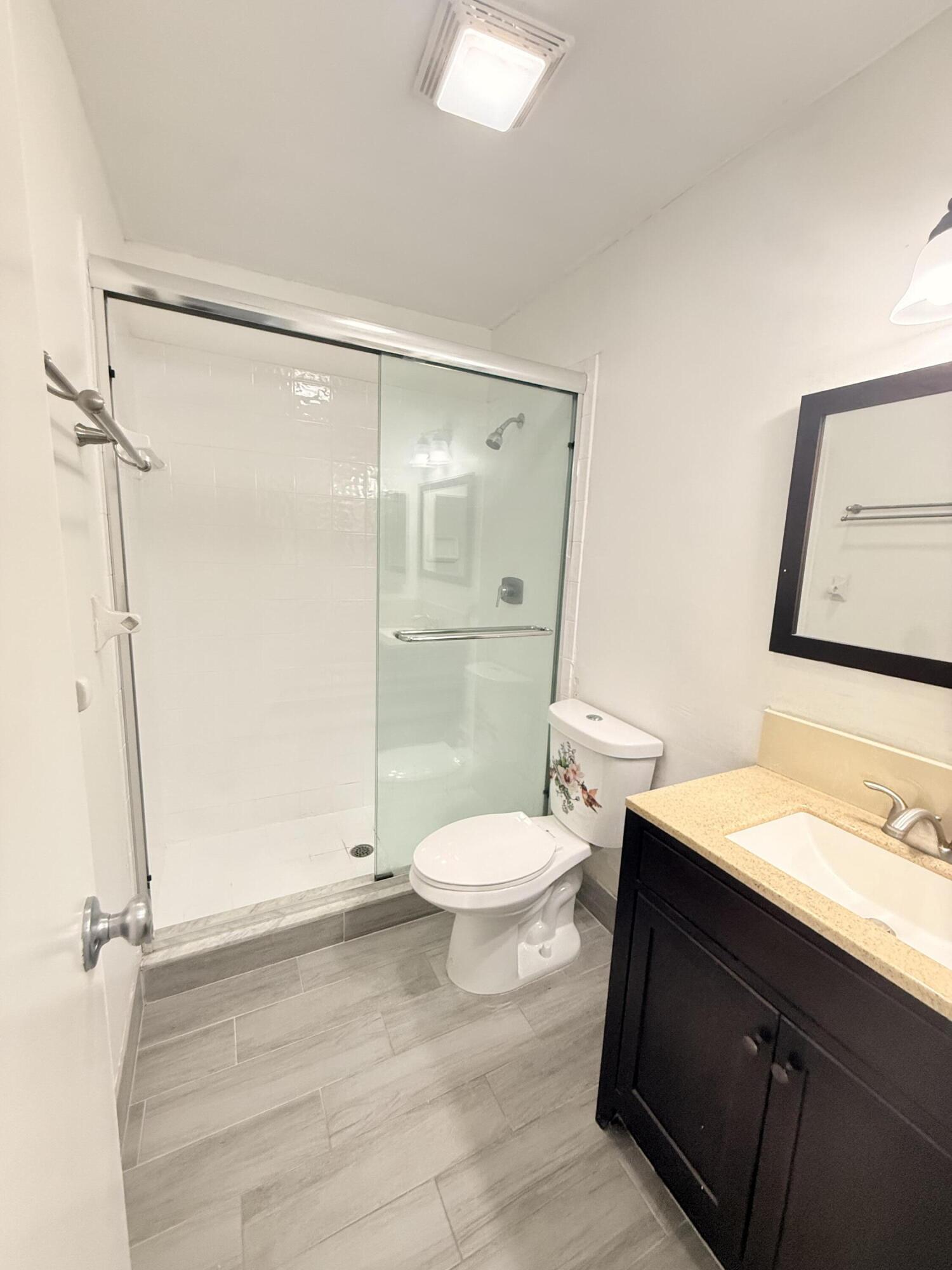 906 Southwest 9th St Circle, Unit 204 Boca Raton, FL 33486 - Photo 19 of 39 a bathroom with a toilet a sink and shower