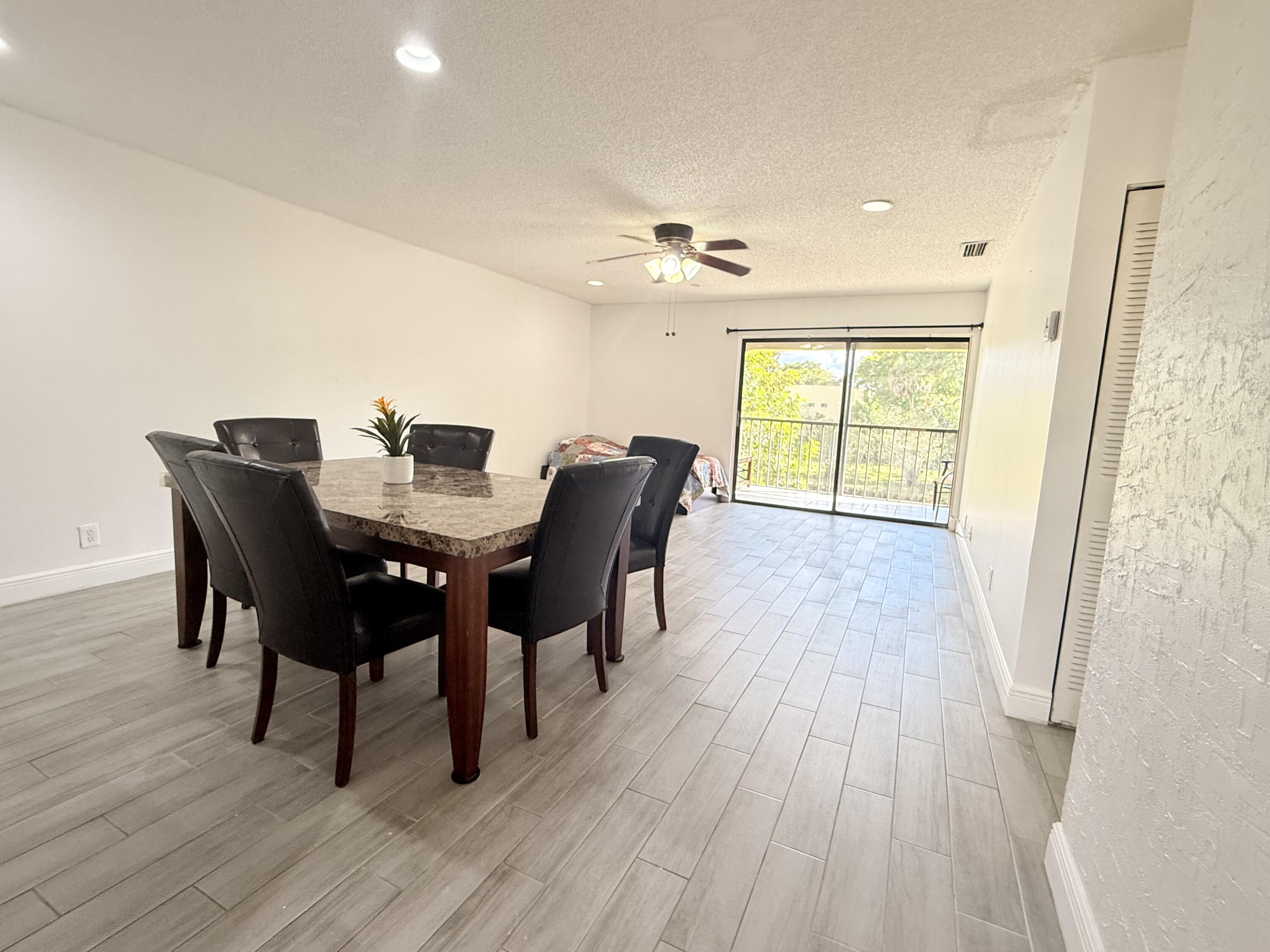 906 Southwest 9th St Circle, Unit 204 Boca Raton, FL 33486 - Photo 6 of 39 a view of a dining room with furniture window and wooden floor