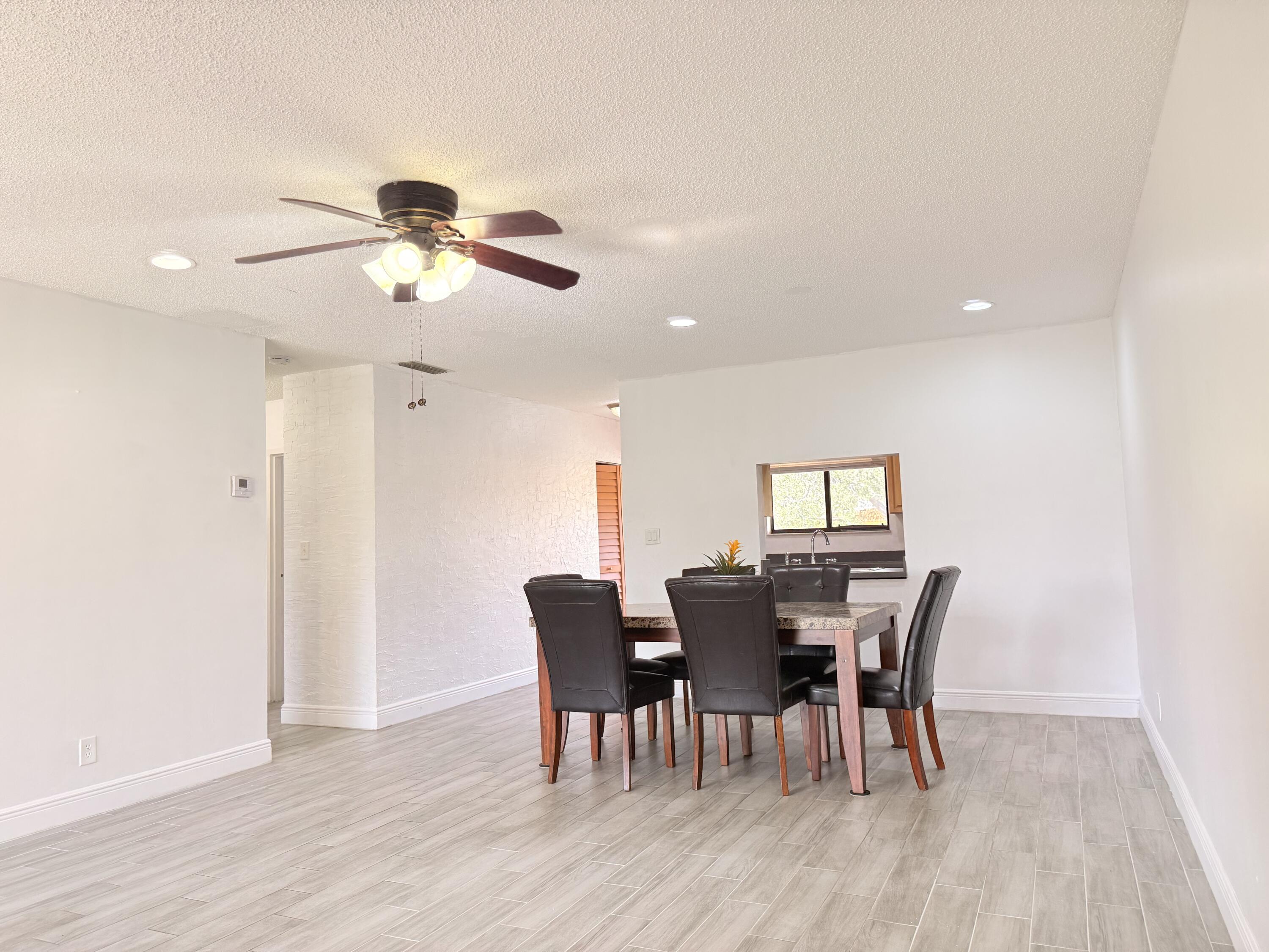 906 Southwest 9th St Circle, Unit 204 Boca Raton, FL 33486 - Photo 7 of 39 a view of a dining room with furniture and wooden floor