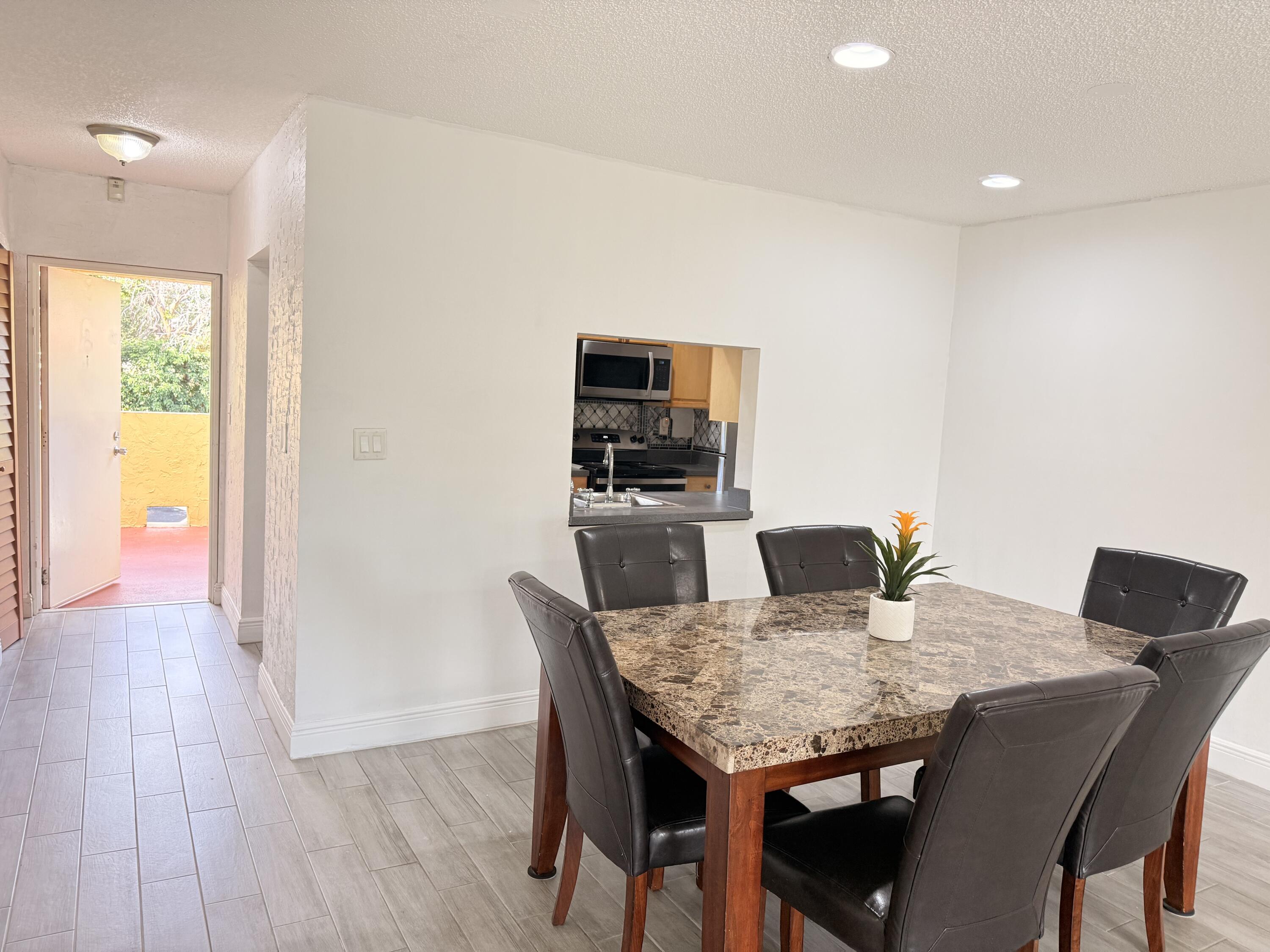 906 Southwest 9th St Circle, Unit 204 Boca Raton, FL 33486 - Photo 8 of 39 a view of a dining room with furniture and wooden floor
