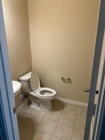 a white toilet sitting next to a shower